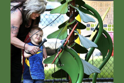  mother helping son use playground equipment