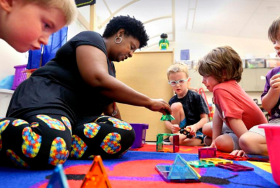   teacher on floor playing with students